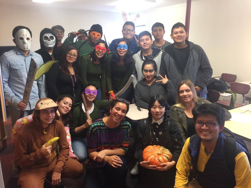 adult ESL students pose in their Halloween costumes