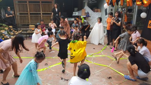 young students dressed in Halloween costume play a skipping game