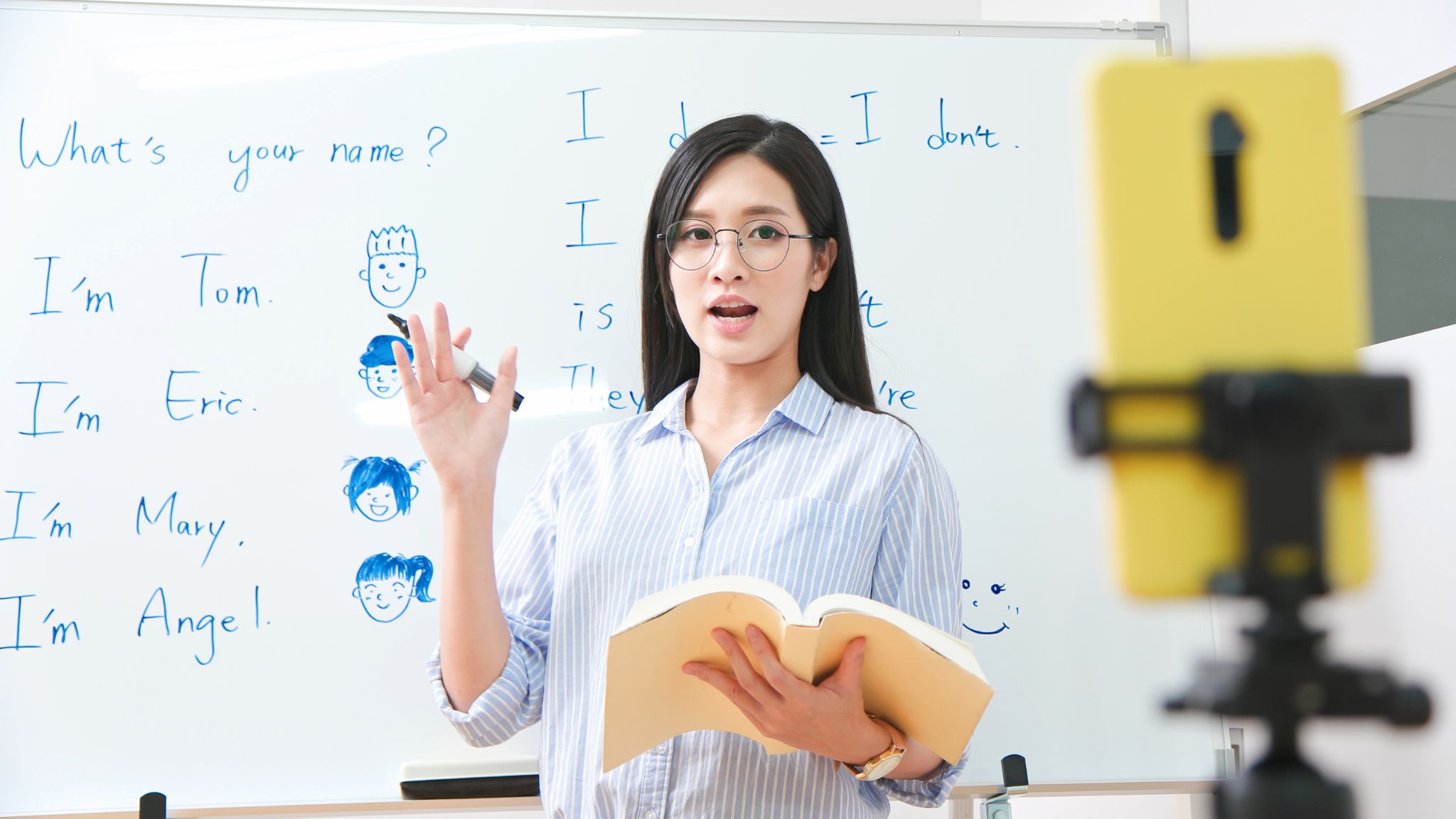 a Business English teacher recording a lesson with her phone