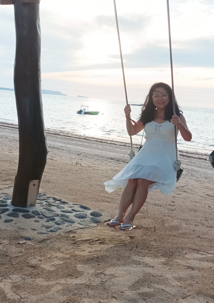 Belinda sitting on a swing at the beach in Madagascar.