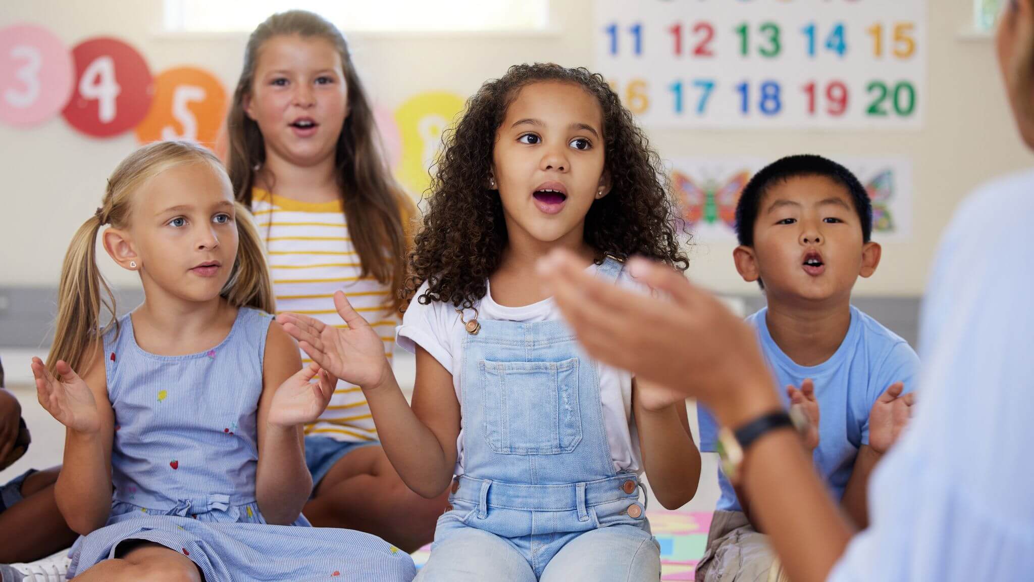 young students singing and clapping.