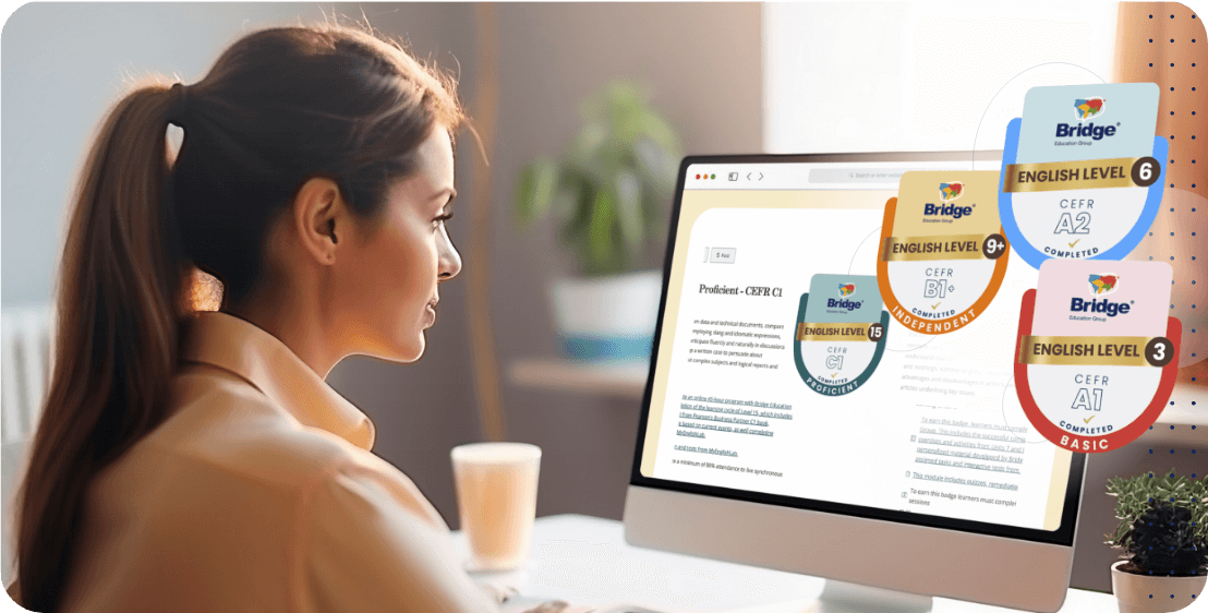 Introducing Bridge Digital Badges A woman is sitting at a desk, looking at a computer screen displaying an online learning course. Various digital certification badges for different English proficiency levels (A1 to B2) from Bridge are visible on the screen. A plant and a cup are placed beside her.